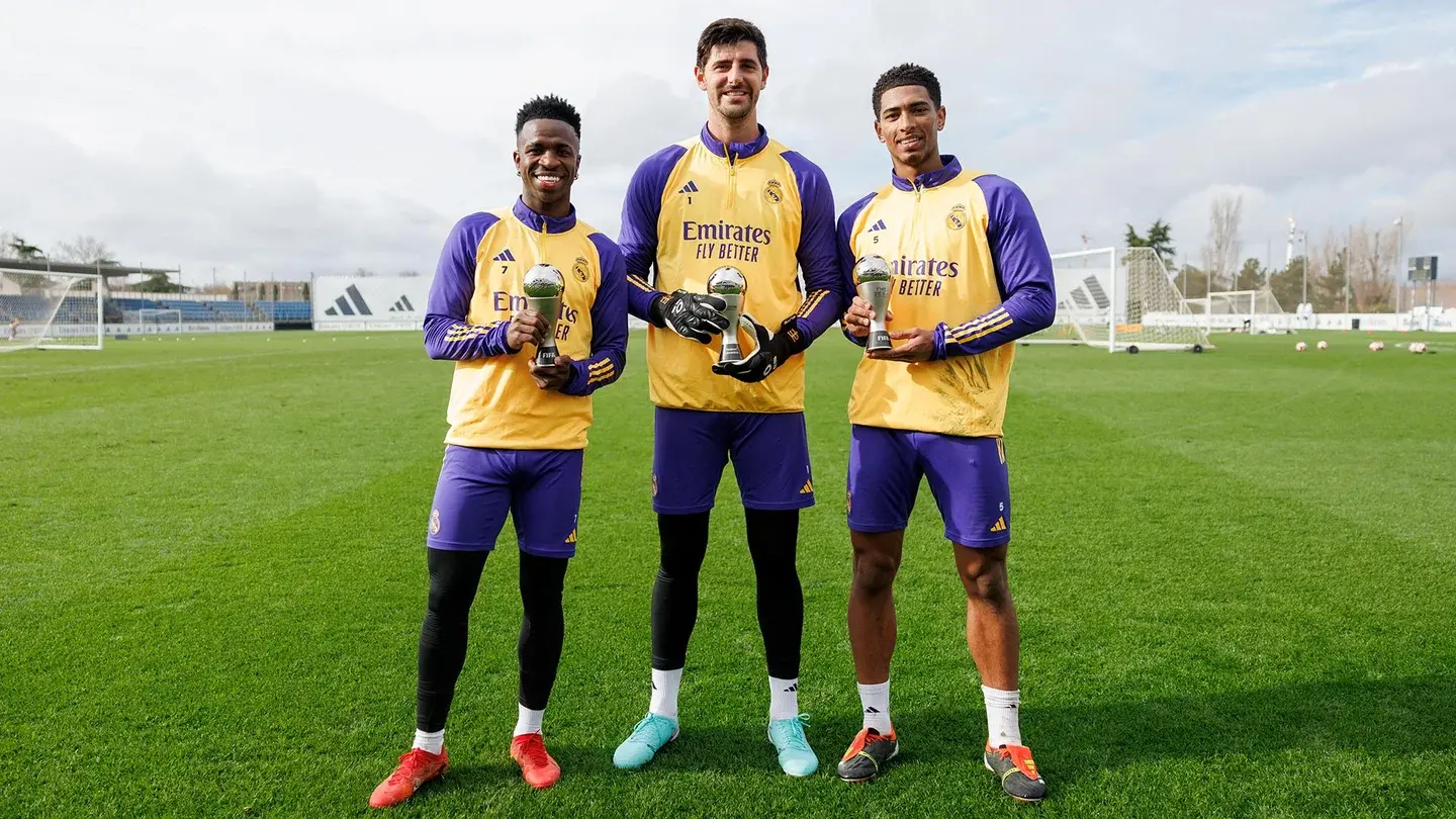 Jude Bellingham, Vinicius Jr y Thibut Courtuis posando con el trofeo del fifa best team.