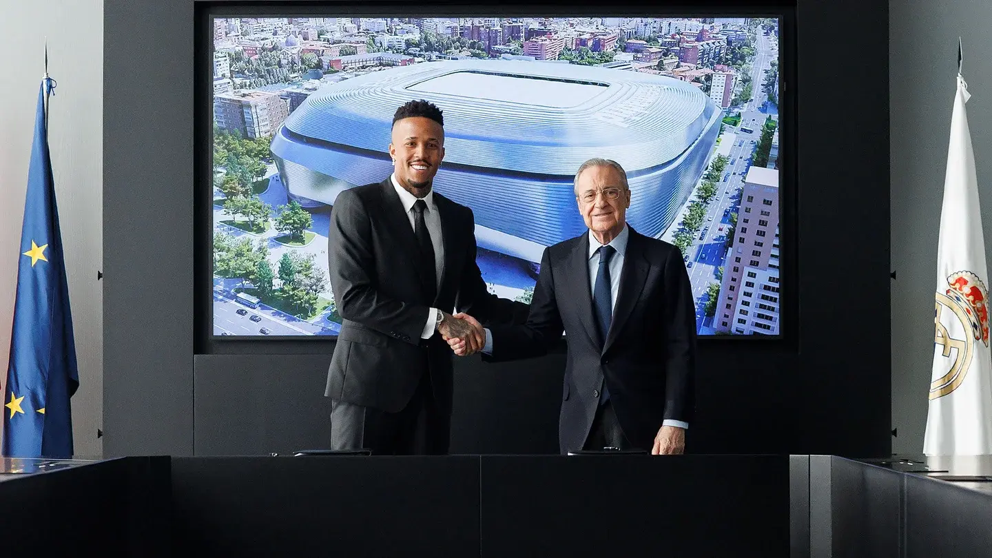 Eder militao posando junto a Florentino Perez tras firmar el renuevo de su contrato